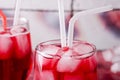 Cold cherry drink with ice cubes and cocktail tubes in glasses, on pink background Royalty Free Stock Photo