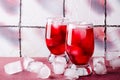 Cold cherry drink with ice cubes in glasses, on pink background Royalty Free Stock Photo