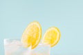 Cold citrus beverage with orange, alcohol, ice in misted shot glass on green background, closeup, top, edge, details.