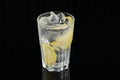 Cold cocktail with lemon. A glass of dew drops. Freshness, alcohol, bar. Black background