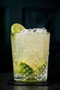 Cold cocktail with lime and lemon. A glass of dew drops. Freshness, alcohol, bar. Black background