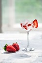 Cold cocktail with vodka, strawberry syrup, fresh strawberries and crushed ice in glasses on a light background Royalty Free Stock Photo