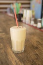 A cold coffee cocktail in a clear glass with a straw on a wooden bar counter Royalty Free Stock Photo