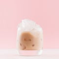 Cold coffee drink with creamy alcoholic liqueur, ice cubes in wet glass on fresh pastel pink background, square, details, closeup. Royalty Free Stock Photo