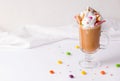 coffee with ice cream, whipped cream decorated with multi-colored sweets on a white background. copy space