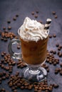 Cold coffee with ice and milk in a glass and whipped cream on top