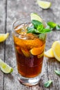 Cold cola with mint, lime and ice in glass on wooden background. Summer drinks and alcoholic cocktails Royalty Free Stock Photo