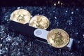 cold cryptocurrency wallet and a three gold bitcoin and ethereum coin on silver shiny background