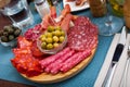Cold cuts from ham, sausages on wooden plate