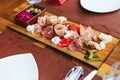 Cold cuts on wooden board with prosciutto, bacon, salami and sausages. Meat platter appetizers served with pickle and olives. Royalty Free Stock Photo