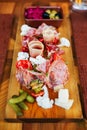 Cold cuts on wooden board with prosciutto, bacon, salami and sausages. Meat platter appetizers served with pickle and olives. Royalty Free Stock Photo