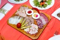 Cold cuts on wooden plate on banquet table Royalty Free Stock Photo