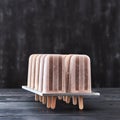 Cold dessert, coffee ice cream on a stick in the molds on a dark wooden table with copy space. Royalty Free Stock Photo