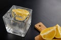 A cold drink in a glass container. Water with ice and lemon on a dark table Royalty Free Stock Photo