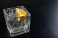 A cold drink in a glass container. Water with ice and lemon on a dark table Royalty Free Stock Photo