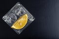 A cold drink in a glass container. Water with ice and lemon on a dark table Royalty Free Stock Photo