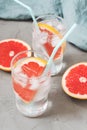 Cold drink with grapefruit and ice. Drink in a glass with a blue tube and a grapefruit slice.