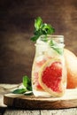 Cold drink with grapefruit and soda, mint and ice in a glass bot Royalty Free Stock Photo