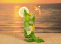 Cold drink with lemon slice against the sea sunset Royalty Free Stock Photo