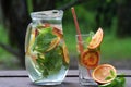 Cold drinks cocktail with red orange and mint in glass and jar. Refreshment lemonade on wooden table. Close up, copy space