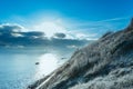 Cold, early morning view of a sloping cliff covered with frost.