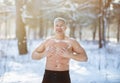 Cold exposure training concept. Joyful senior guy tempering his body with snow at frosty winter forest Royalty Free Stock Photo