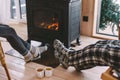 Closeup photo of human feet in warm woolen socks over fire place Royalty Free Stock Photo