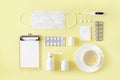 Cold and flu treatment set. Pills, throat spray, medical mask, thermometer, recipe on simple yellow background. Health care therap