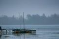 A cold foggy morning on the shore of Lake Wendouree in Ballarat, Victoria, Australia. Small sail boats moored alongside an old Royalty Free Stock Photo