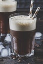 Cold frappe coffee with ice and foam in large glasses on brown b