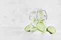 Cold fresh detox beverages of green cucumber with soda water, bubbles, ice cubes on simple soft bright white background. Royalty Free Stock Photo