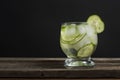 Cold fresh lemonade with cucumber, ice and mint leaves over wooden table and black background. Fresh summer drink in glass. Copy s Royalty Free Stock Photo