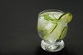 Cold fresh lemonade with cucumber, ice and mint leaves over wooden table and black background. Fresh summer drink in glass. Copy s Royalty Free Stock Photo