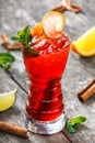 Cold fresh red lemonade with mint, orange, cinnamon and ice in glass on wooden background. Summer drinks Royalty Free Stock Photo