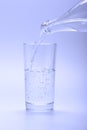 Cold fresh water pouring into glass from a bottle Royalty Free Stock Photo