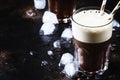 Cold frothy frappe coffee in large glasses on brown background,