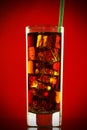 Cold glass of cola drink with ice cubes isolated on red background Royalty Free Stock Photo