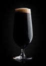 Cold glass of dark beer with foam and dew Royalty Free Stock Photo