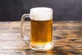 Cold glass of lager beer with foam and dew on wooden table Royalty Free Stock Photo