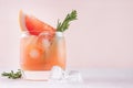 Cold grapefruit alcohol cocktail in misted glass with rosemary and grapefruits slice closeup on pastel fashion pink background. Royalty Free Stock Photo