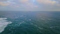 Cold gray ocean rippling under heavy cloudy sky drone. Ship floating in distance Royalty Free Stock Photo
