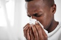 This cold has me feeling blue. a young man blowing his nose at home. Royalty Free Stock Photo