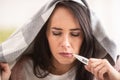 Cold having woman measures fever by holding thermometer in her mouth Royalty Free Stock Photo