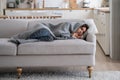 Sick female covered with wool blanket plaid resting on couch, feeling cold at home on winter days Royalty Free Stock Photo