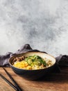 Cold Korean kuksi soup with vegetables, scrambled eggs, beef and noodles in a bowl and chopsticks on rustic wood background Royalty Free Stock Photo