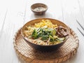 Cold Korean kuksi soup with vegetables, scrambled eggs, beef and noodles in a bowl and chopsticks on a white wood background Royalty Free Stock Photo
