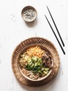 Cold Korean kuksi soup with vegetables, scrambled eggs, beef and noodles in a bowl and chopsticks on a white wood background. Top Royalty Free Stock Photo