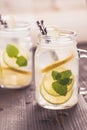 Cold Lemonade with Ice. Lemon and Mint Leaves in Mason Jar on Dark Wooden Background. Royalty Free Stock Photo