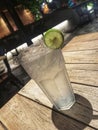 Cold lychee splash glass with orange garnish on wooden table