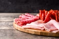 Cold meat on cutting board on wooden table. Ham, salami, sausage mortadella and turkey Royalty Free Stock Photo